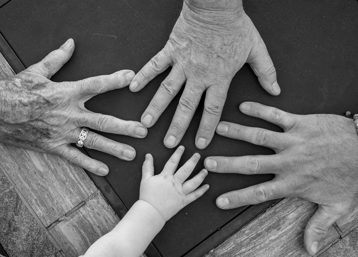 Mani di più generazioni appoggiate su un tavolo
